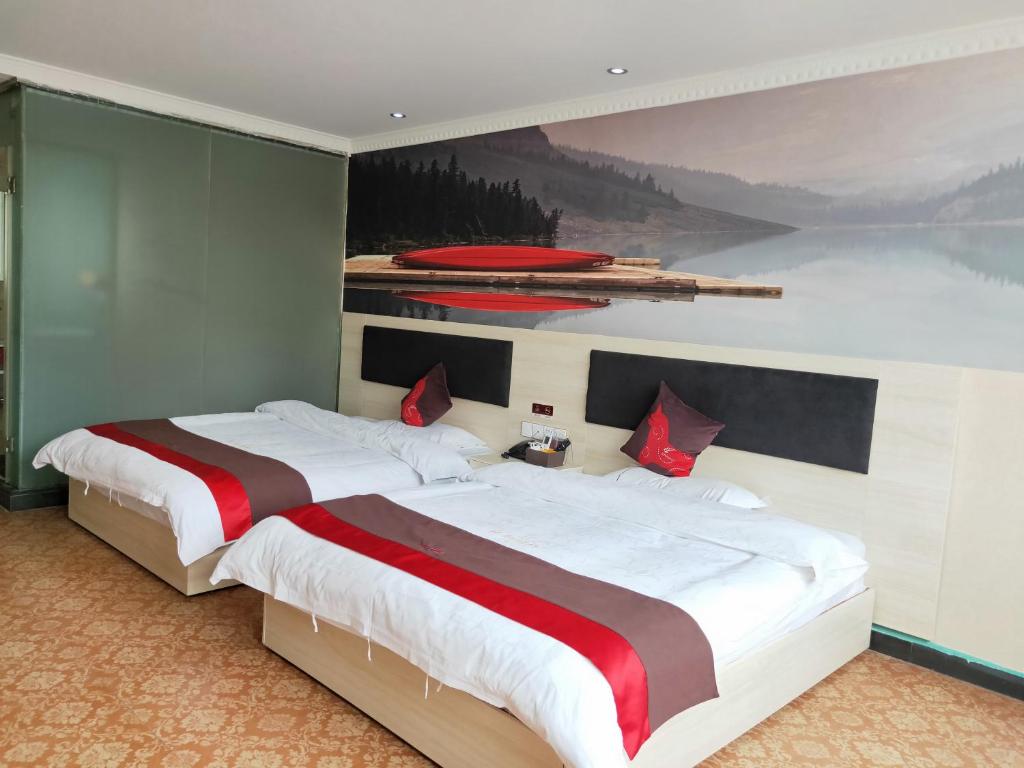 a bedroom with a large bed with a painting on the wall at JUN Hotels Nanchang Honggutan New District Cuiyuan Road Subway Station in Nanchang