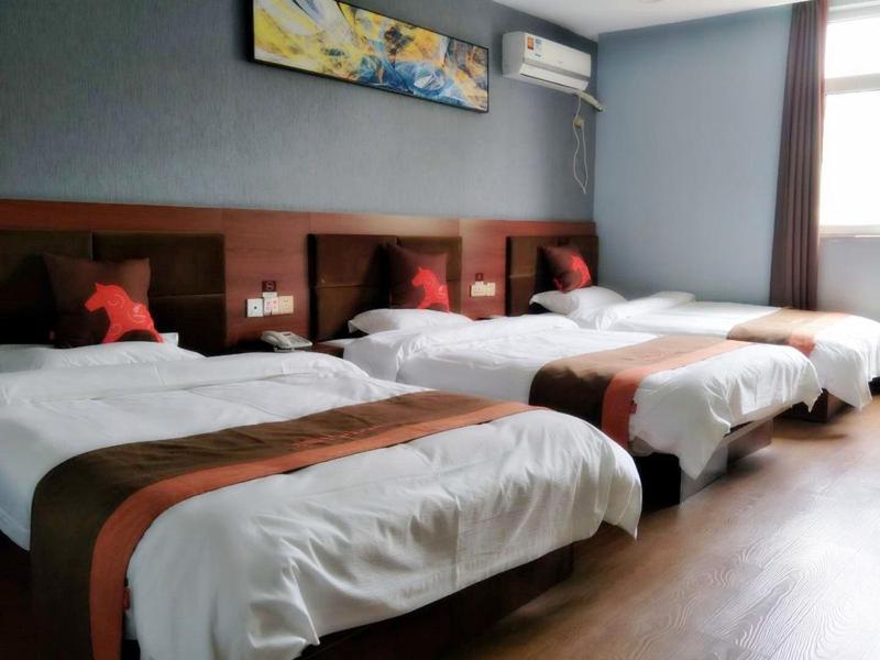 un grupo de 4 camas en una habitación de hotel en JUN Hotels Hebei Handan Weixian Bus Station Store, en Handan