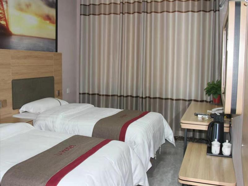 a hotel room with two beds and a table at Thank Inn Chain Hotel Shandong Linyi Linshu County Cangshan South Road in Linyi