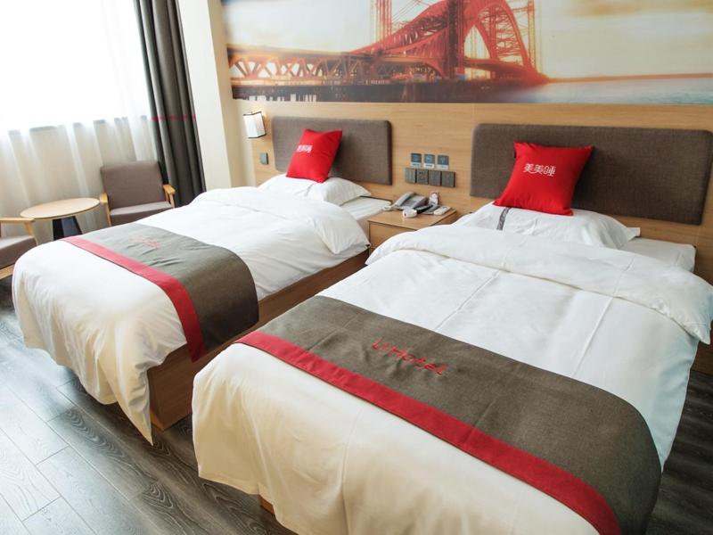 2 camas en una habitación de hotel con almohadas rojas en Thank Inn Chain Hotel Shanxi Taiyuan Yangqu County Plaza, en Taiyuán