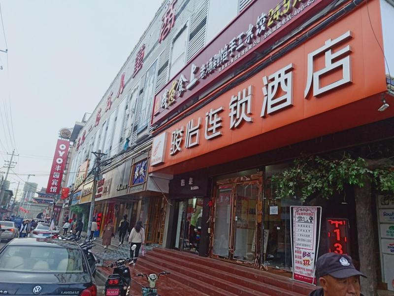 eine Straße mit Gebäuden und Autos auf einer belebten Straße in der Unterkunft JUN Hotels Yulin Yuyang District Xinlou Store in Yulin