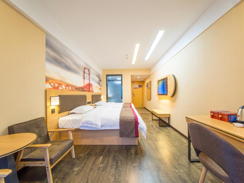 a hotel room with a bed and a table and chairs at Thank Inn Chain Hotel Guizhou Zunyi Xinpu New District Meidi City in Zunyi