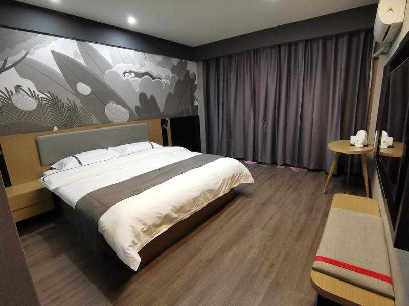 a bedroom with a large bed and a table at Thank Inn Chain Hotel Shanxi Changzhi Lihou County Lihou Ancient City in Changzhi