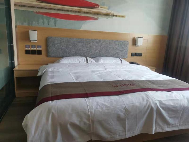 a large bed in a hotel room with a large white bedspread at Thank Inn Chain Hotel Hebei Hengshui Zaoqiang County Daying Town West Asia Fur Shop in Hengshui