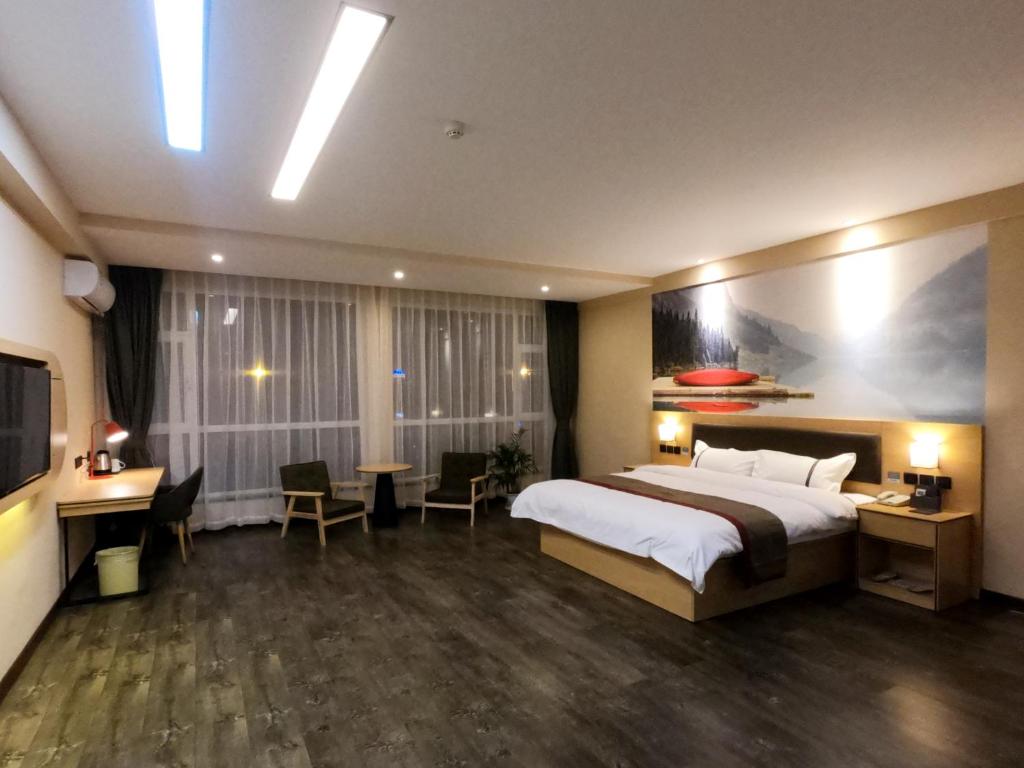 a hotel room with a large bed and a desk at Thank Inn Plus Hotel Shanxi Shuozhou Shuocheng District Zhangliao South Road in Shuozhou