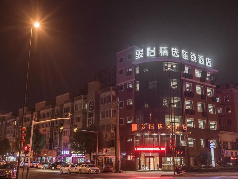 a large building with lights on top of it at night at JUN Hotels Jiangsu Wuxi East Railway Station Store in Zhaqiao