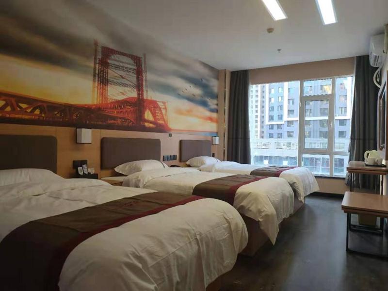 a hotel room with three beds and a large window at Thank Inn Chain Hotel Lanzhou Chengguan District Jiaojiawan Subway Station in Lanzhou