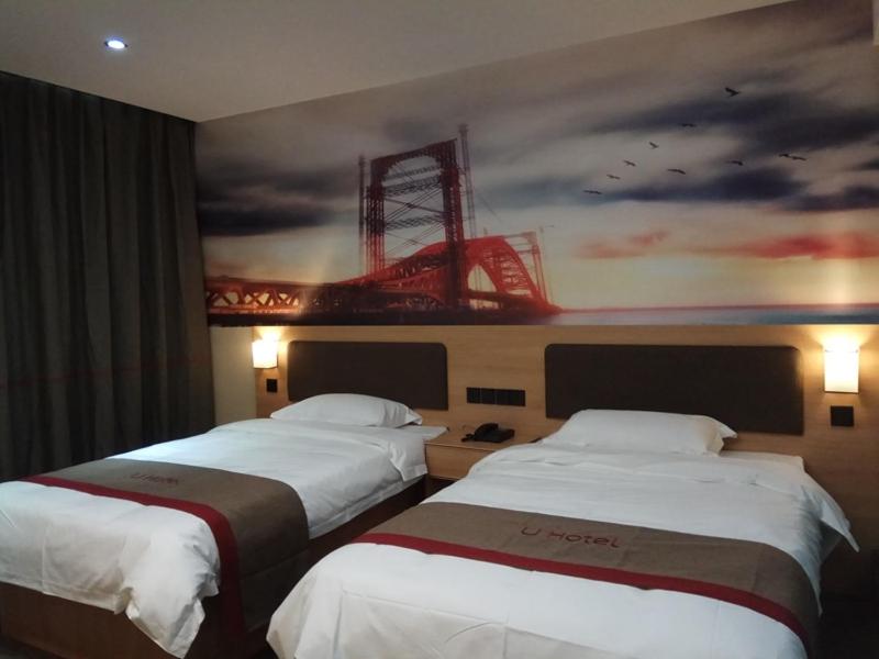 Thank Inn Chain Hotel Shandong Ji'nan Jiyang Yingcai Academy (North) : سريرين في غرفة الفندق مع لوحة على الحائط