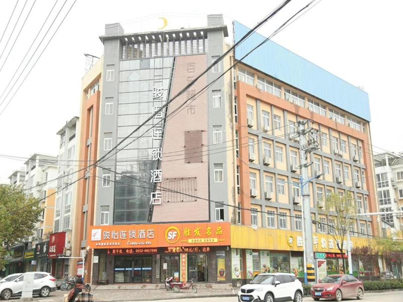 a large building with cars parked in front of it at JUN Hotels Anhui Bangbu Guzhen County Huihe Road Store in Qiaokou