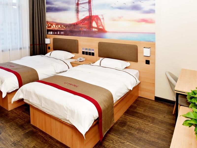 two beds in a room with a painting of a bridge at Thank Inn Chain Hotel Panjin Shuangtaizi District Railway Station in Panjin