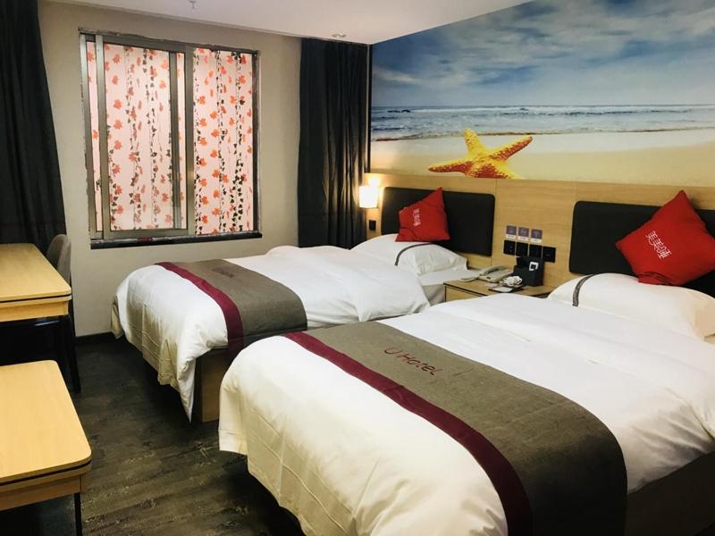 um quarto de hotel com três camas e uma janela em Thank Inn Chain Hotel Guangdong Yunfu Xinxing County Times Square Store em Yunfu
