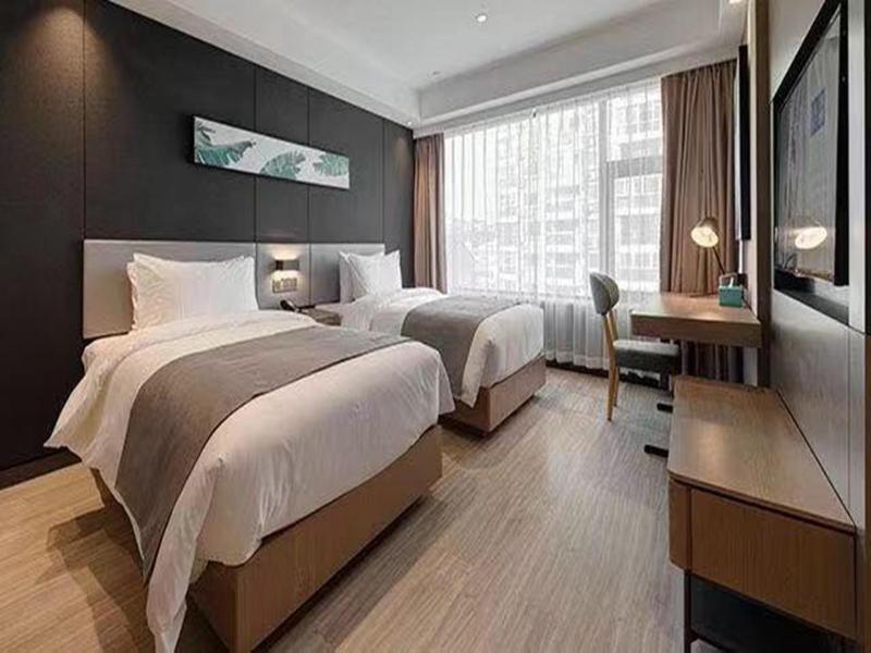 Habitación de hotel con 2 camas y escritorio en Up And In Guangxi Nanning Shanglin County Longhu Xincheng en Shanglin