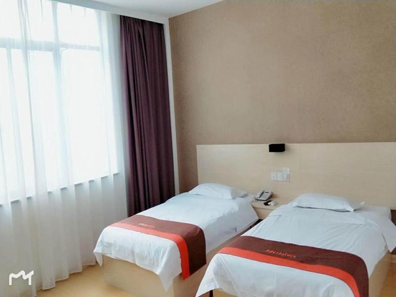 Ένα ή περισσότερα κρεβάτια σε δωμάτιο στο JUN Hotels Anhui Huangshan Tunxi District Huangshan Old Street