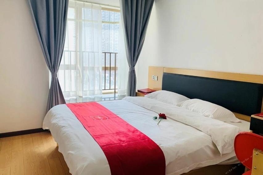 a bedroom with a large bed with a red and white blanket at Thank Inn Chain Hotel Guiyang Nanming District Huaguoyuan Yan'an South Road in Guiyang