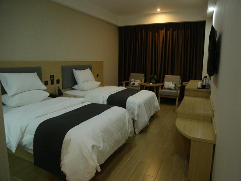 a hotel room with two beds and a desk at Up and In Heze Development zone Huanghe Road in Heze