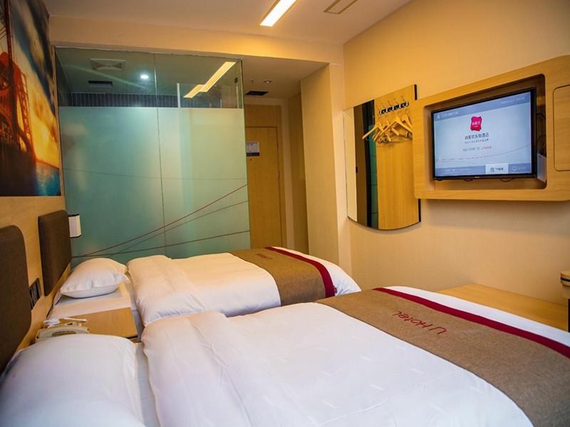 a hotel room with two beds and a flat screen tv at Thank Inn Chain Hotel Guizhou Zunyi Renhuai People's Hospital Store in Zunyi