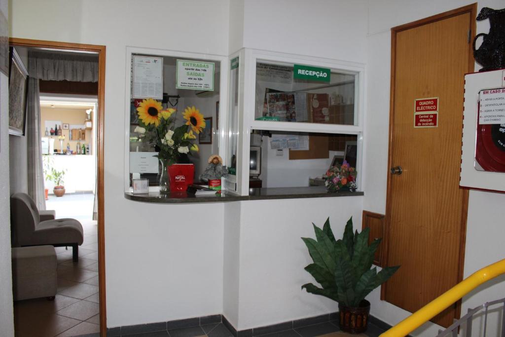 a waiting room with a counter with flowers in it at Dom Fernando I in Loulé