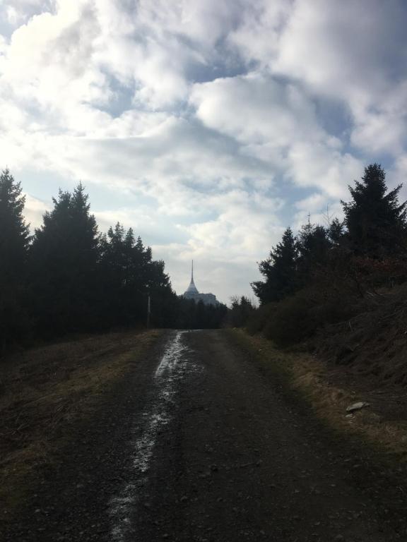 a dirt road with a building in the distance at Turistická Chata Pláně in Český Dub