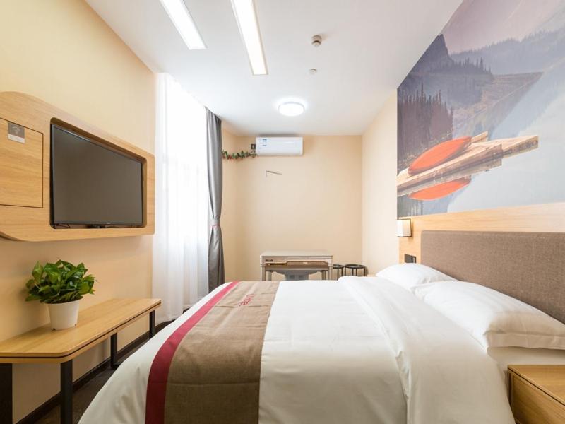 um quarto com uma cama grande e uma televisão em Thank Inn Chain Hotel Shanghai Songjiang District Yongfeng Road Store em Xangai