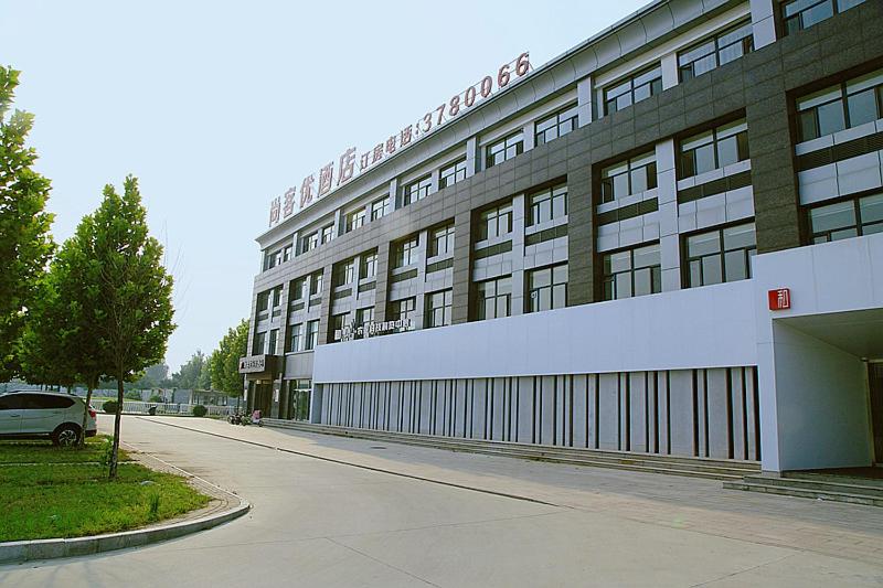 a large building on the side of a street at Thank Inn Chain Hotel Hebei Baoding Jingxiu District Lugang International in Baoding