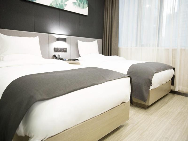 ein Hotelzimmer mit 2 Betten und einem TV in der Unterkunft Up And In Guizhou Qian Southwest Xingyi City Mengle City in Xiawutun