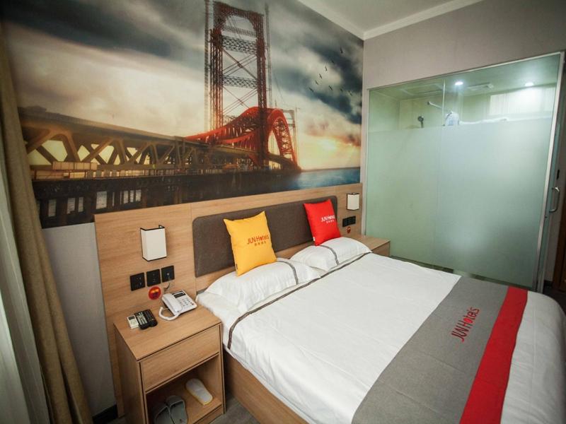 a bedroom with a bed and a painting of a bridge at JUN Hotels Hebei Xingtai Qiaodong District South Xinhua Road in Xingtai