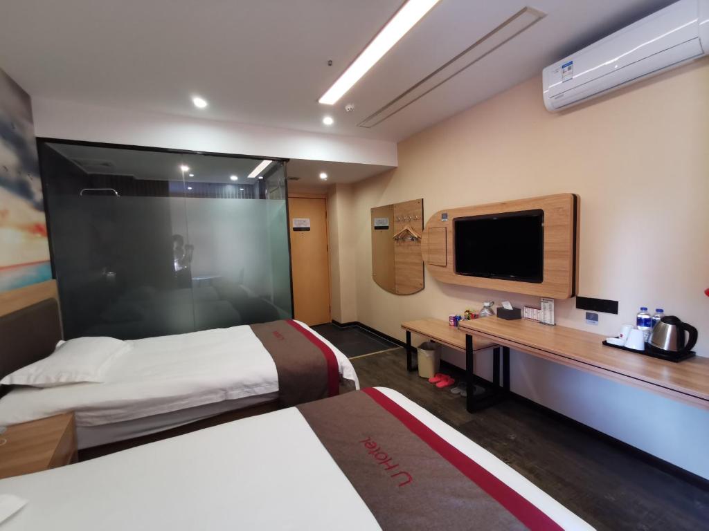 a hotel room with a bed and a desk and a tv at Thank Inn Chain Hotel Anhui Fuyang Funan County Yunhe East Road Store in Fuyang