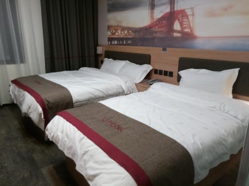 twee bedden in een hotelkamer naast elkaar bij Thank Inn Chain Hotel Jiangsu Suzhou Wuzhong Hongzhuang Subway Station in Suzhou