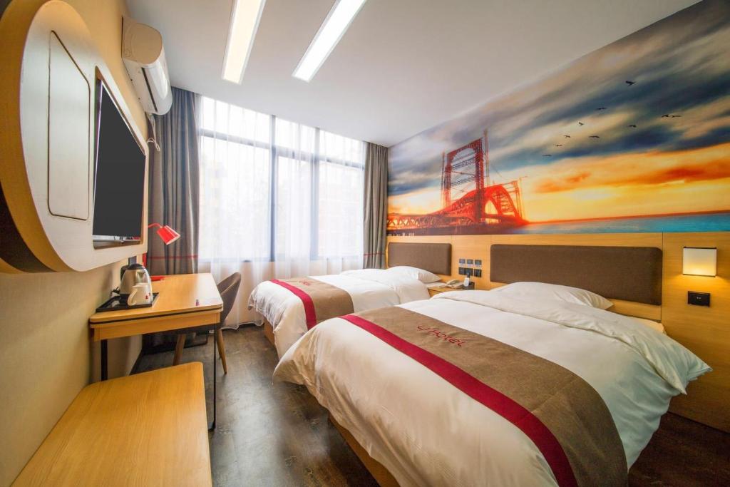 a hotel room with two beds and a tv at Thank Inn Plus Hotel Guizhou Zunyi Old Railway Station in Zunyi
