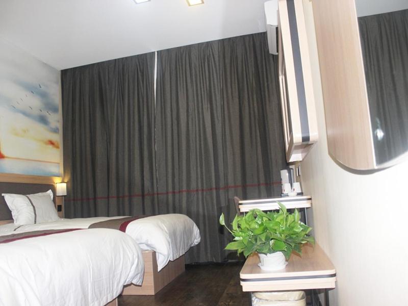 een hotelkamer met 2 bedden en een potplant bij Thank Inn Chain Hotel Hebei Chengde Shuangqiao District Chenghuangmiao in Chengde
