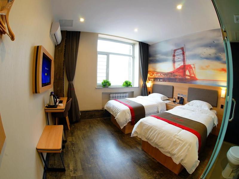 a hotel room with two beds and a window at Thank Inn Chain Hotel Heilongjiang Jiamusi Qianjin District Railway Station in Jiamusi