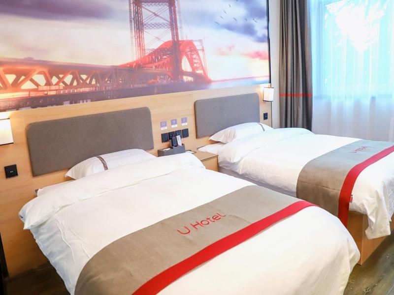 2 camas en una habitación de hotel con vistas a un puente en Thank Inn Chain Hotel Shanxi Yuncheng Ruicheng County Dongmao Plaza Store, en Yuncheng