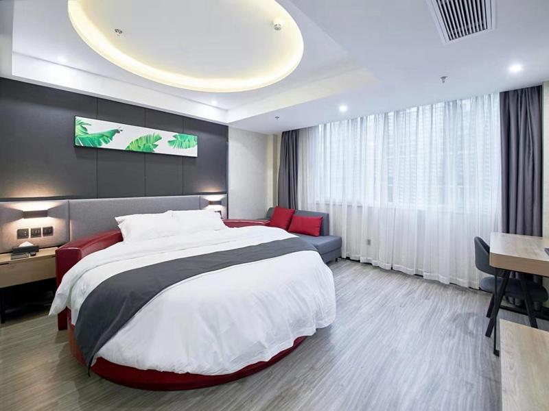 a large bedroom with a large bed and a desk at Up And In Hubei Xianning Tongshan County Building Material Market in Xianning