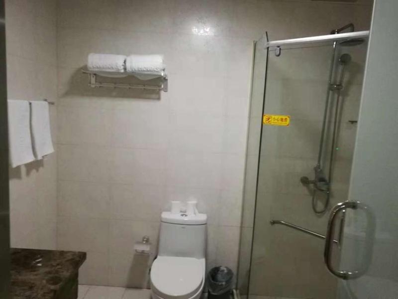 y baño con aseo y ducha acristalada. en JUN Hotels Zhejiang Jiaxing Haiyan Qiyuan North Road, en Jiaxing