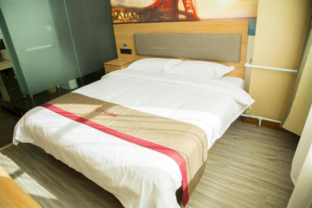 een groot bed in een hotelkamer bij Thank Inn Chain Hotel Hebei Handan Wu'an City Bus Station in Handan