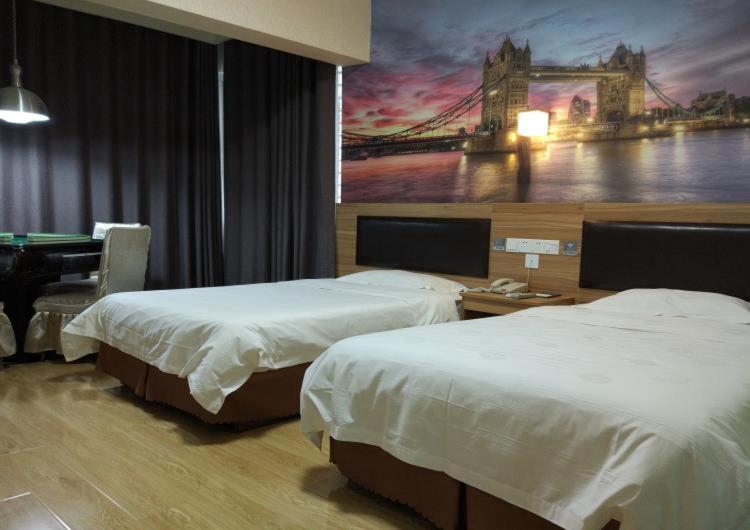 a hotel room with two beds and a painting on the wall at Thank Inn Chain Hotel Xiaogan Hanchuan West Lake Avenue in Xiaogan