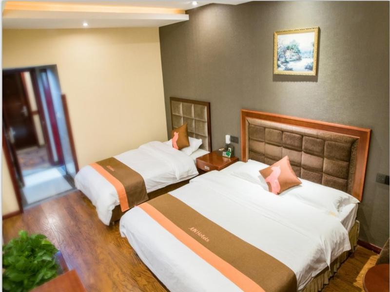two beds in a hotel room with at JUN Hotels Sichuan Xhengdu Pidu University City in Chengdu