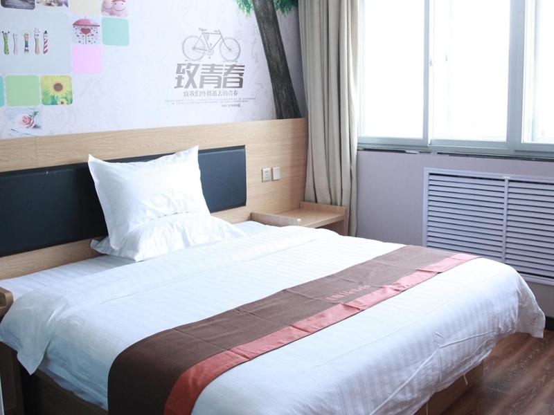 a bedroom with a large bed in a room at JUN Hotels Hebei Langfang Guangyang Langfang Station in Langfang