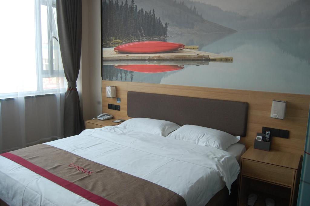 uma cama num quarto de hotel com um quadro na parede em Thank Inn Chain Hotel Weifang High-tech Zone Weifang East Expressway Intersection em Weifang