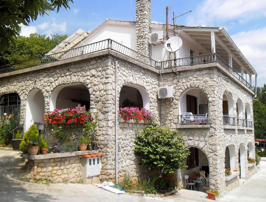a stone building with flower boxes and a balcony at Apartments Kestenovi Dvori in Opatija