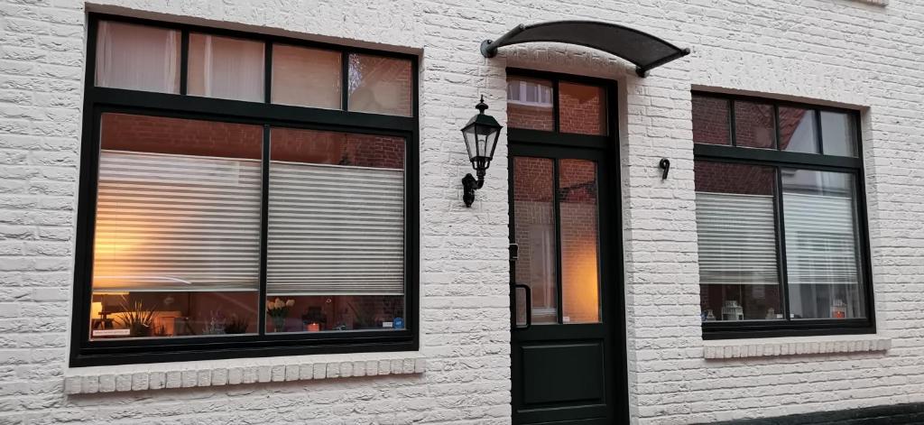 a white brick building with a black door and windows at Sehr schöne Ferienwohnung im historischen Borken-Gemen in Borken