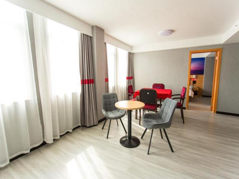 um quarto com uma mesa e cadeiras e uma mesa e cadeiras em JUN Hotels Hubei Xianning Tongshan County Jiugong Avenue em Xianning