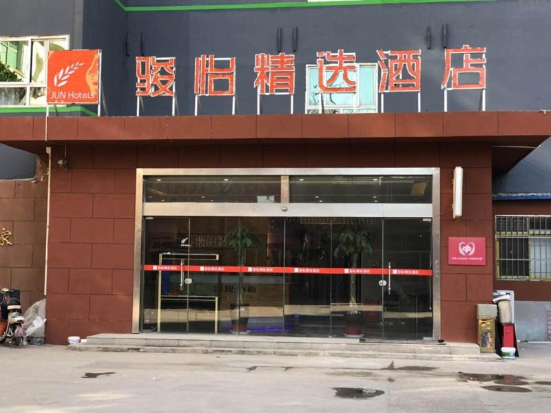 una tienda frente a un edificio con letreros. en JUN Hotels Henan Anyang Yindu DIstrict Tiexi Road en Anyang