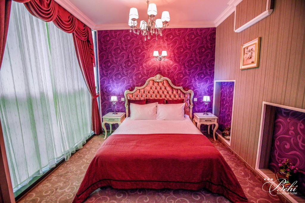 a bedroom with a large bed with purple walls at Boutique Hotel Behi in Kŭrdzhali