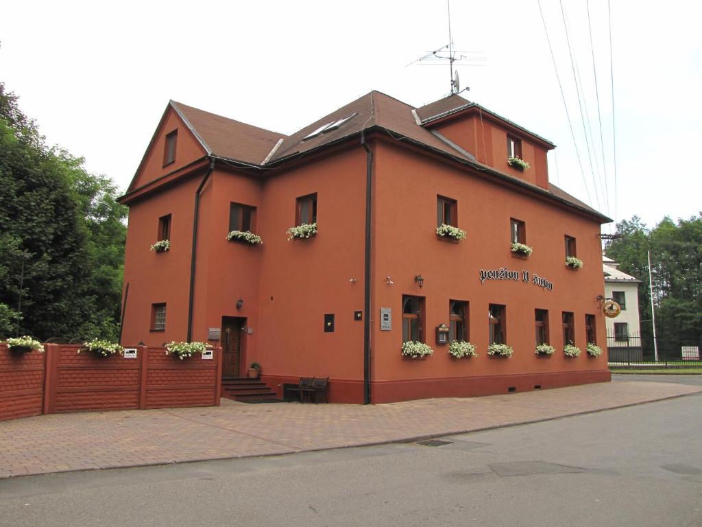 a large orange building with flowers in the windows at Penzion Vulture Havířov in Havířov