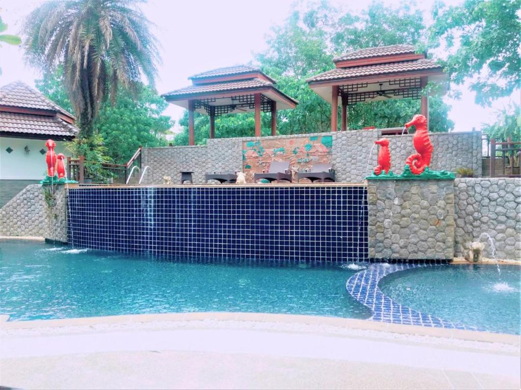 a swimming pool with a water fountain in a yard at Thai Modern Resort & Spa in Chalong