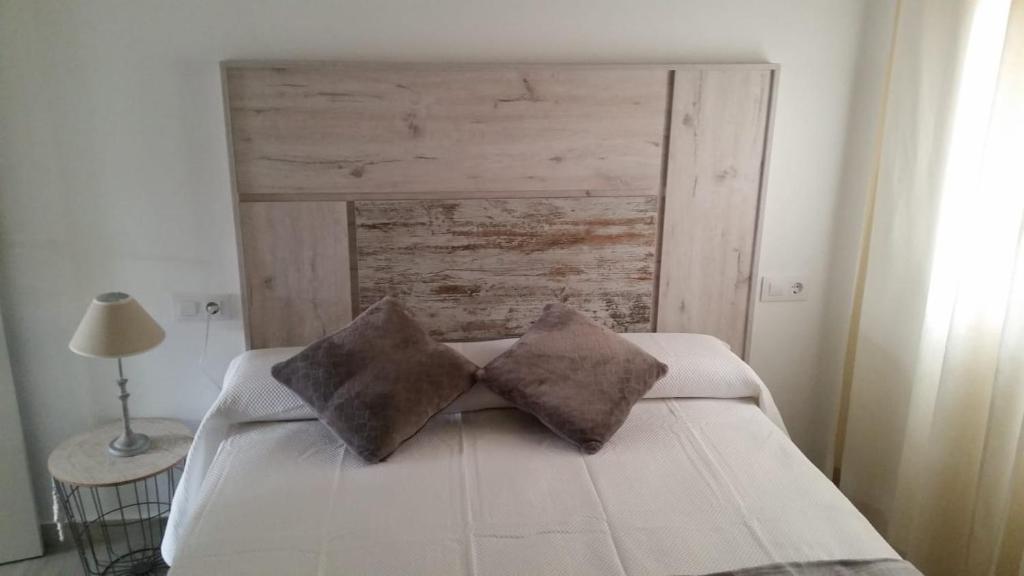a bedroom with a bed with two pillows on it at Apartamento Pimienta in Tarifa