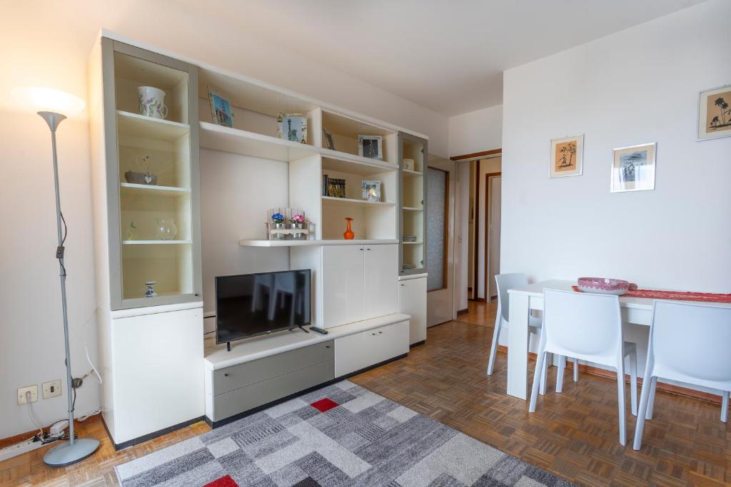 ein Wohnzimmer mit einem TV und einem Esstisch in der Unterkunft ZIA DINA APARTMENT in Pasian di Prato