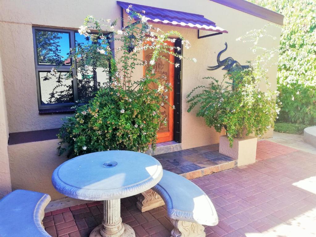 a blue bench sitting in front of a house at Safari Guesthouse in Vryburg