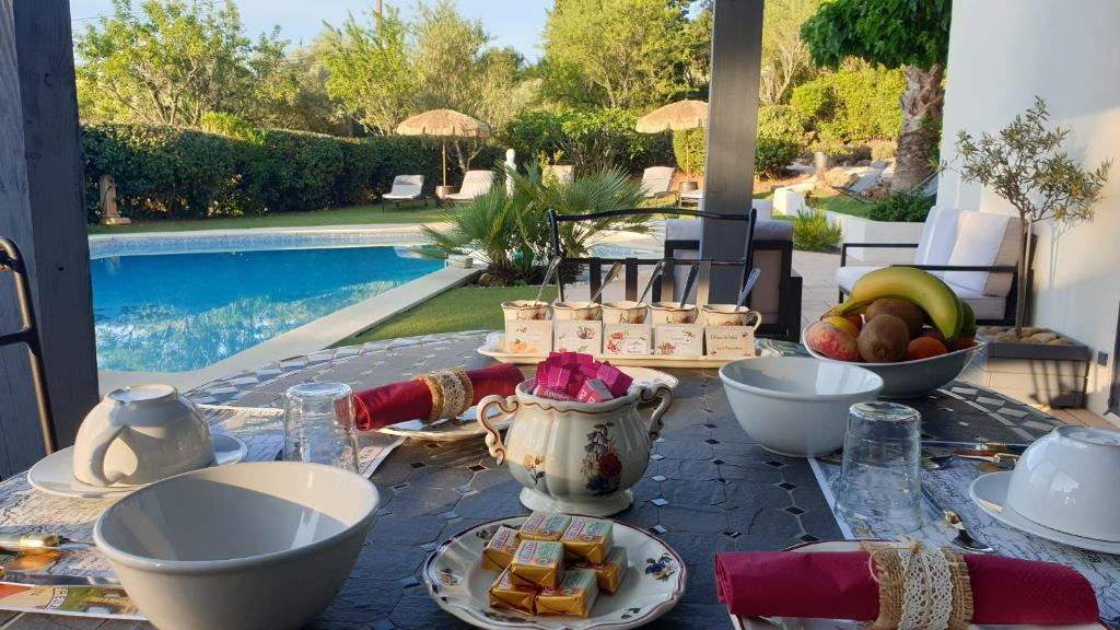a table with food on it next to a pool at La Villa d&#39;Olivène in Cuers